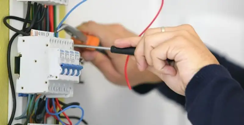 Electrician installing and adjusting circuit breakers in an electrical panel in Dallas, TX