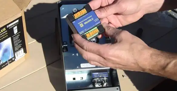 Electrician installing whole home surge protection unit inside main electrical panel in Dallas, TX