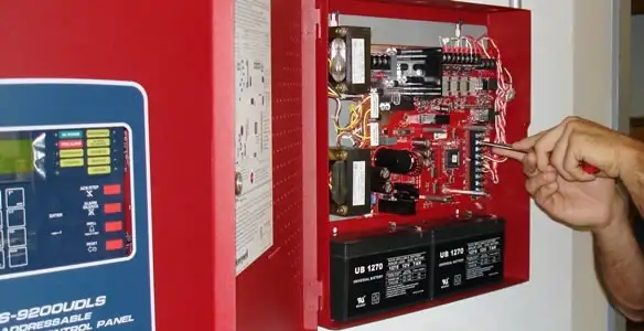 fire alarm installation service showing technician configuring fire alarm control panel in Dallas, TX