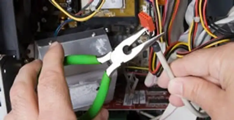 Licensed electrical contractor performing electrical repair with tools in Garland, TX