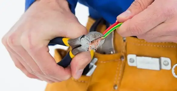 licensed electrician securing electrical wiring with professional tools during service work in Dallas, TX