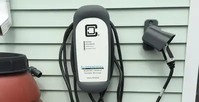 Outdoor electric vehicle charger installation on residential wall in Dallas, TX