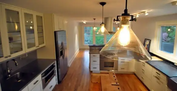 Residential electrician installing modern indoor light fixture in a home in Dallas, TX